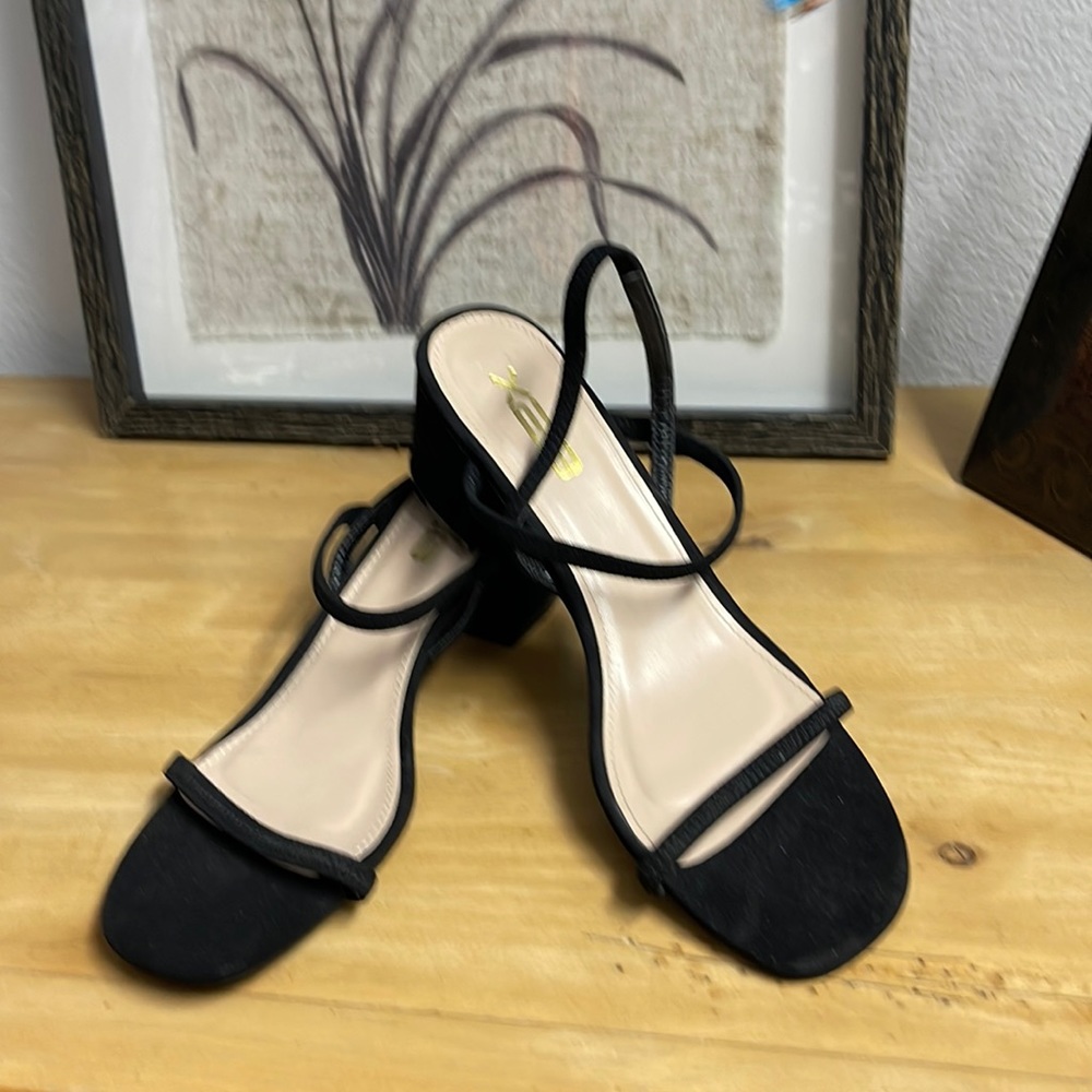 Black suede elastic strap sandal with block heel.